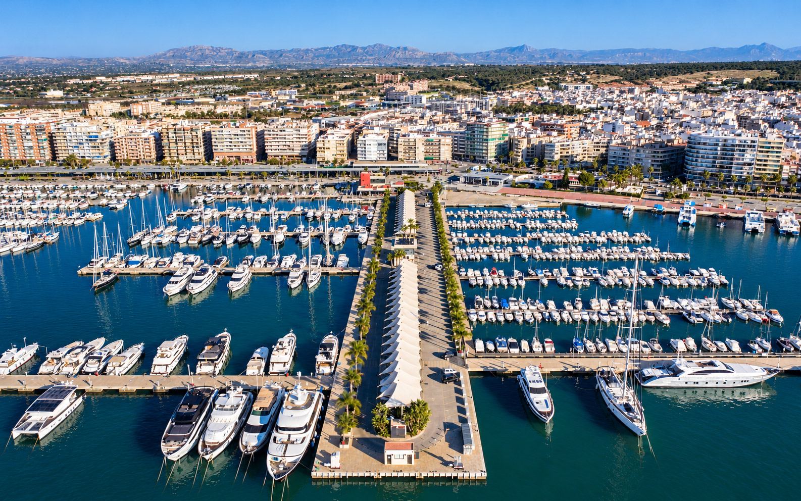 Vue aérienne d'un port de plaisance avec pontons, bateaux amarrés et travel lift